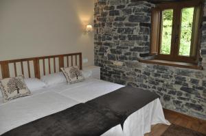 a bedroom with a bed and a brick wall at Casa La Ribera in Lon