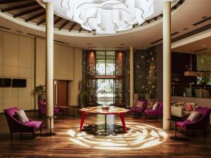 a room with a table and chairs and a chandelier at Mercure Iguazu Hotel Iru in Puerto Iguazú