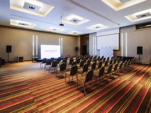 a conference room with chairs and a projection screen at Mercure Iguazu Hotel Iru in Puerto Iguazú +100 photos
