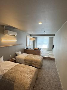ein Hotelzimmer mit zwei Betten und einem Fenster in der Unterkunft Shoji Mount Hotel in Fujikawaguchiko