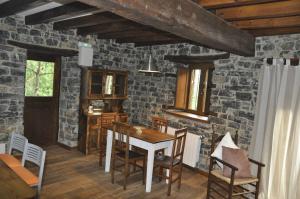a dining room with a table and a stone wall at Casa La Ribera in Lon