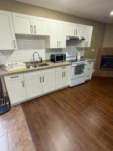 a kitchen with white cabinets and a sink at Home sweet home in Windsor +11 photos