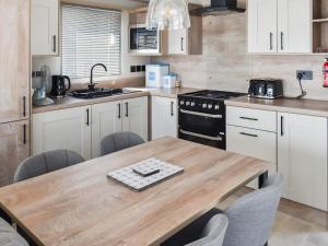 een keuken met een houten tafel en een fornuis bij Seaview One - Uk50167 in Corton