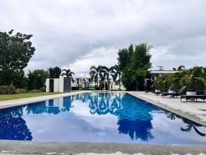 a swimming pool with blue water in a park at Cana Blessed Guest House in Urdaneta in San Jose