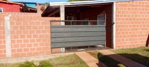 a brick building with a garage with a gate at Depto alem in Leandro N. Alem