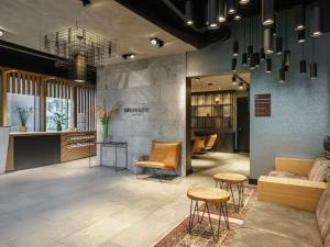una sala de espera con sillas, mesa y sillas en Mercure Amsterdam Sloterdijk Station, en Ámsterdam