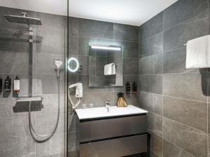un baño con ducha y lavabo en Mercure Amsterdam Sloterdijk Station, en Ámsterdam 41 fotos más