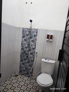 a bathroom with a toilet and a shower at Favian Homestay in Purwokerto +20 photos