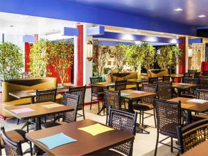 an empty restaurant with tables and chairs and plants at Ibis Styles Porto Alegre Centro - proximo rodoviaria, Araujo Vianna e hospitais in Porto Alegre