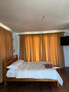 a bed in a bedroom with orange curtains at Rumah Sungai Impiana PCB room 2 in Gua Sai