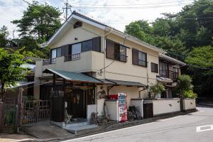 a building with a store on the side of a street at 民宿かまだ MinshukuKamada in Hatsukaichi