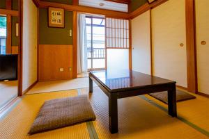 a living room with a table and a television at 民宿かまだ MinshukuKamada in Hatsukaichi
