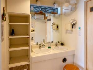 a bathroom with two sinks and a mirror at 民宿かまだ MinshukuKamada in Hatsukaichi