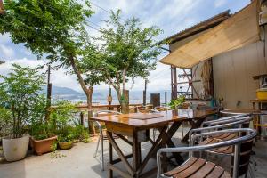 a wooden table and chairs on a patio at 民宿かまだ MinshukuKamada in Hatsukaichi