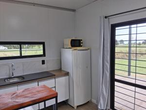 een keuken met een koelkast en een magnetron bij Gran Casa de Campo - Chacra Lavanda in Salto