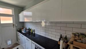 a kitchen with white and black tiles on the wall at Best room near the stadium, train station, & parliament precinct in Wellington