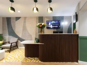 Una televisión o centro de entretenimiento en Ibis Styles Paris Jardin de la Villette - Rénové en 2025