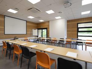 an empty classroom with a large table and chairs at ibis Styles Vierzon in Vierzon +135 photos