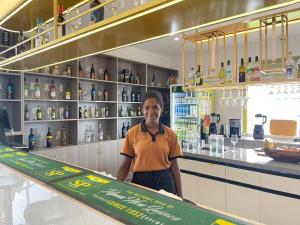 a man standing behind a counter in a bar at Tang Mow Hotel in Wewak