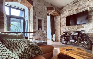 a living room with a motorcycle in a stone wall at PULA Big Green Oasis House with Garden,Near Colosseum in Pula