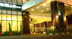 a large building with a sign on the side of it at Travello Hotel Manado in Manado