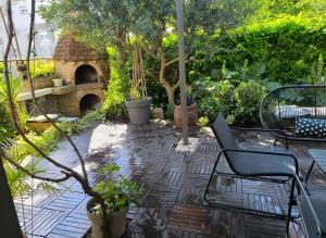 a patio with a table and chairs and a stone fireplace at PULA Big Green Oasis House with Garden,Near Colosseum in Pula