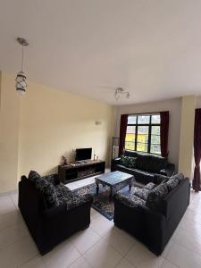 a living room with two couches and a coffee table at Cameron Prima Villa Homestay in Tanah Rata