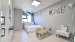 a small bedroom with a bed and a table at Donghae Fine and You Oceancity Hotel by SND in Donghae
