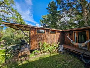 a log cabin with a hammock in the yard at Arauca Lodge in Villa Ventana