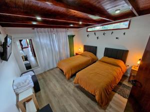 two beds in a bedroom with birds on the wall at Arauca Lodge in Villa Ventana