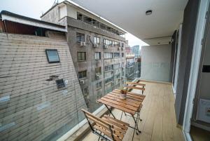 een balkon met een houten tafel en stoelen in een gebouw bij Luxury Stay in a Prime 1BR in Santiago