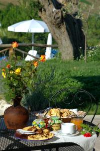 un tavolo con piatto di cibo e un vaso con fiori di Agriturismo Tenuta Sol Alto a Monsampolo del Tronto
