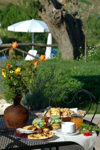 stół z talerzem jedzenia i wazon z kwiatami w obiekcie Agriturismo Tenuta Sol Alto w mieście Monsampolo del Tronto