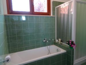 a green tiled bathroom with a tub and a window at IlPoggetto Bed&Breakfast in Civitanova Marche +37 photos