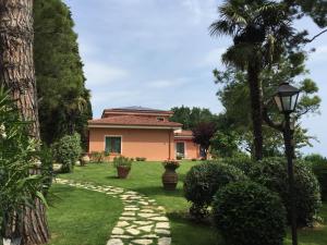 a house with a palm tree and a walkway at IlPoggetto Bed&Breakfast in Civitanova Marche