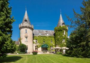 a castle with two towers on a green lawn at Château de Bellecroix in Chagny