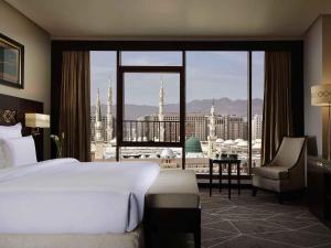 a hotel room with a bed and a view of a city at Pullman Zamzam Madina in Al Madinah +162 photos