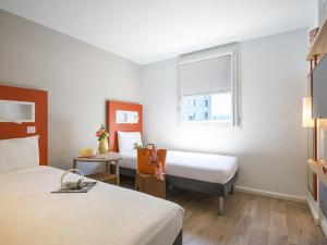 a hotel room with two beds and a window at ibis budget Nice Californie Lenval in Nice