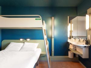 a bedroom with a bunk bed and a sink at ibis budget Mâcon Nord in Mâcon