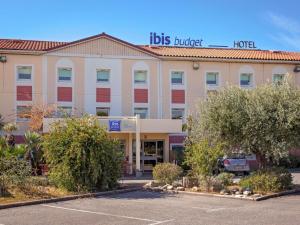 a hotel with a parking lot in front of it at Ibis Budget Fréjus Capitou in Fréjus +48 photos