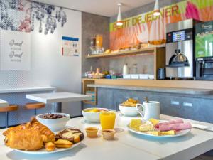 a table topped with plates of food and pastries at Ibis Budget Fréjus Capitou in Fréjus