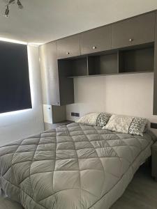 a large bed in a bedroom with a large window at Departamento en Maule, cerca Estadio Nacional y metro Ñuble in Santiago +7 photos