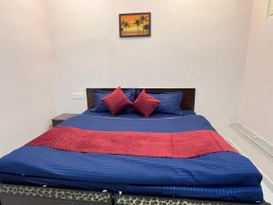 a bedroom with a blue bed with red and blue pillows at Himalayan Wellness Retreat in Rishīkesh +51 photos