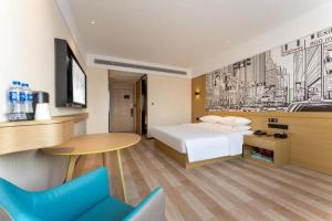 a hotel room with a bed and a table and a desk at City Comfort Inn Wuhan Dongxihu Tianyuan Avenue in Wuhan