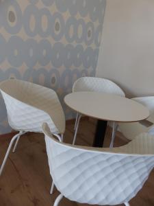 2 sillas y una mesa en una habitación con pared en Parkhotel Heidehof Apartements en Ingolstadt