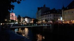 a city at night with a river and buildings at Hostel Sleeping Beauty in Ljubljana +36 photos