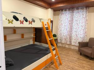 a bunk bed with a ladder in a room at Flat in Gangtok NgiSem Apt 5min away from MG marg in Gangtok