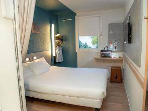 a small bedroom with a white bed and a window at Ibis Budget Le Havre Les Docks in Le Havre