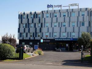 a building with a car parked in front of it at Ibis Budget Le Havre Les Docks in Le Havre