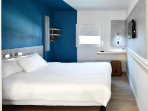 a bedroom with a white bed and blue walls at Ibis Budget Le Havre Les Docks in Le Havre